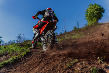 Professional enduro bike rider on action, dirt ride on the muddy road. Motocross sport.  © Malik Nalik