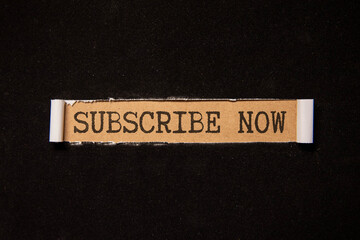 SUBSCRIBE NOW word on a notebook on grey background