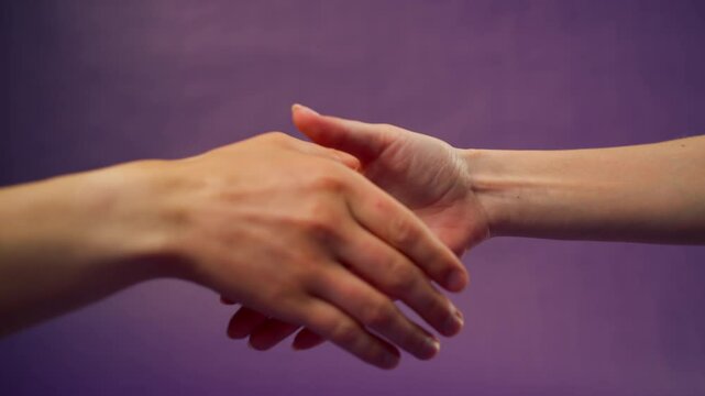 Beautiful female hand on isolated on purple background two hands handshake sign language