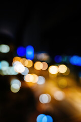 A blurred view of Baku city at night featuring vibrant bokeh lights in various colors, creating a dreamy and abstract effect.