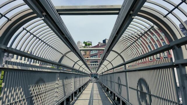 A dollying walking perspective on a New York City pedestrian overpass near the Holland Tunnel in lower Manhattan.  	