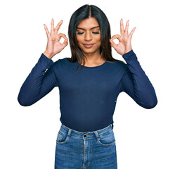 Obraz premium Young latin transsexual transgender woman wearing casual clothes relax and smiling with eyes closed doing meditation gesture with fingers. yoga concept.