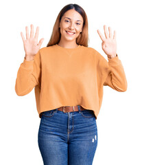 Beautiful young woman wearing casual clothes showing and pointing up with fingers number nine while...