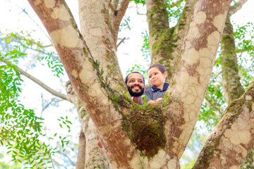 Brazilian father and son share a joyful moment peeking through tree branches, celebrating Father's Day with nature and smiles. Perfect for family, nature, and holiday themes.