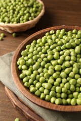 Fresh green peas in bowl on wooden table, closeup