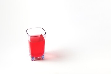 red drink on transparent glass
