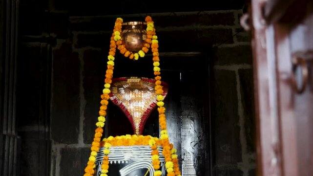 hindu religious god shiva Shivalinga decorated with flowers from different angle at ancient temple video is taken at Kumbhal fort kumbhalgarh rajasthan india.