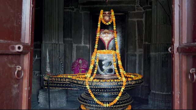 hindu religious god shiva Shivalinga decorated with flowers from different angle at ancient temple video is taken at Kumbhal fort kumbhalgarh rajasthan india.