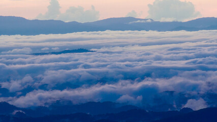 Mountain scenery and sea of ​​mist in the morning. Amazing nature background with clouds and mountain peaks in Thailand.