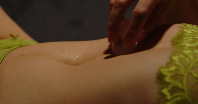 Attractive woman slowly caresses her beautiful body with an ice cube while dressed in sexy lingerie. She slowly rubs the ice cube up her body while the camera follows her hand.