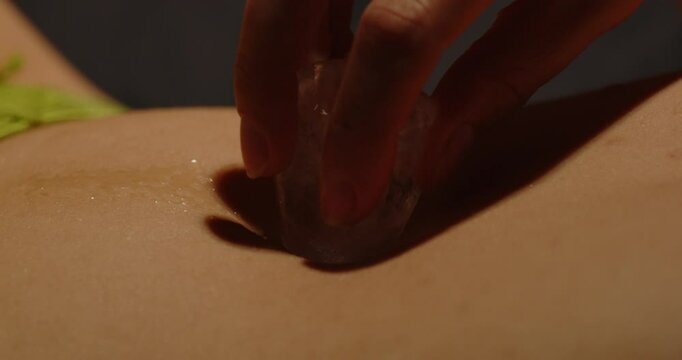 Beautiful macro of an ice cube teasingly being rubbed on the belly of an attractive woman dressed in sexy lingerie