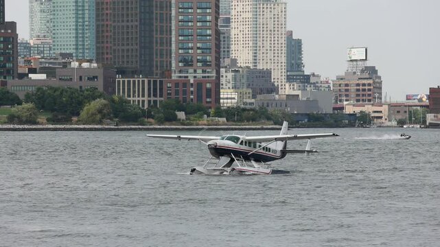 sea plane on east river in new york (tourism, flying, sailing) water airplane prop propeller floating skyline