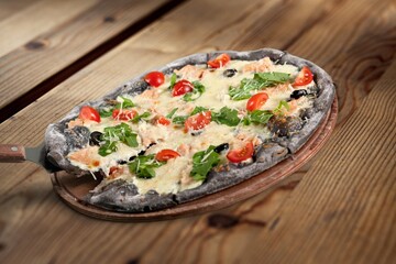 Tasty fresh pizza dish on wooden desk