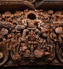 Pediment containing headless bas relief carved in red sandstone of figure without head at Banteay...