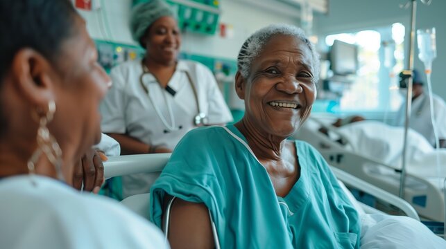 An elderly patient smiles brightly while interacting with a visitor and healthcare staff in a hospital room, showcasing the positive and supportive environment of medical care