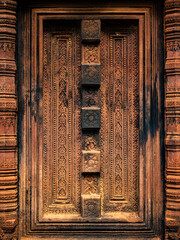 False door bas relief carved in red sandstone at Banteay Srei - citadel of women and beauty - Hindu temple dedicated to god Shiva and Parvati, Siem Reap, Cambodia