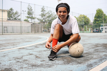 Asian Football Player Getting Ready For The Game Tying His Shoes