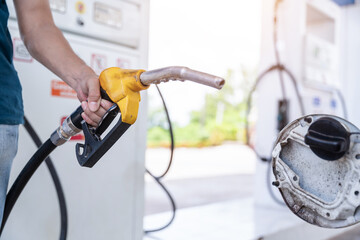 Close-up hand of A male holding a fuel nozzle against on petrol station.