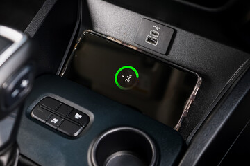 Wireless mobile charger in the modern car. Portable wireless car charger for smartphone.