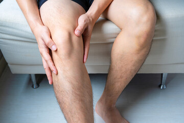 Man with knee pain, he puts his hand on his knee, pain point from osteoarthritis and...