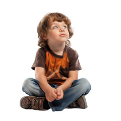 A young child with curly hair sits cross-legged, looking up contemplatively, wearing a brown and orange shirt with blue jeans