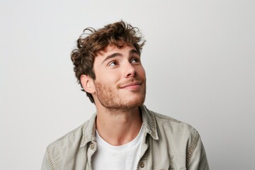 Fototapeta premium Portrait of a happy European man dressed casually looking satisfied and smiling noticing something in the distance