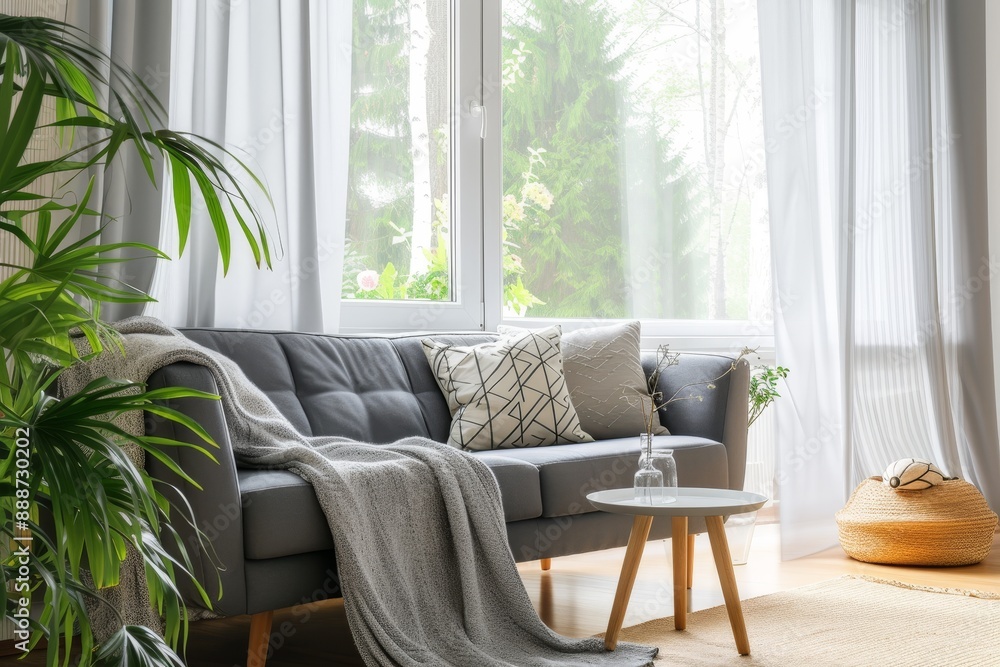 Sticker Stylish living room with a grey sofa and pillows by the window