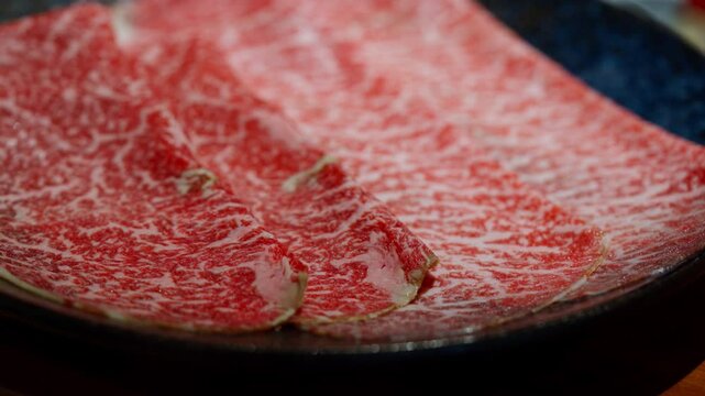 Close-up of Japanese A5 beef slices, showcasing the marbled texture and rich color. Perfect for illustrating the premium quality and exquisite marbling of Wagyu beef, ideal for culinary, gourmet.