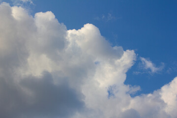 It's a blue sky with atmospheric puffy clouds.