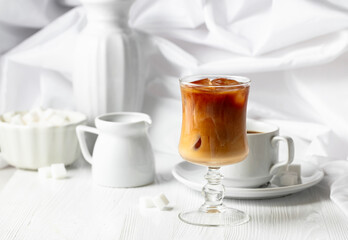 Iced coffee with cream and cup of black coffee.