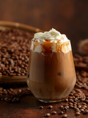 Iced caramel latte topped with whipped cream and caramel sauce.
