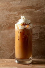 Iced caramel latte topped with whipped cream and caramel sauce.