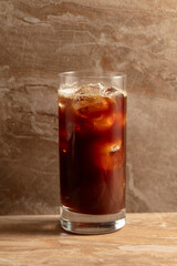 Black iced coffee on a ceramic table.