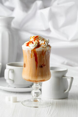 Iced caramel latte topped with whipped cream and caramel sauce.