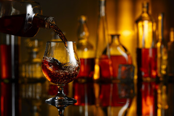 Pouring brandy from a bottle into a glass.