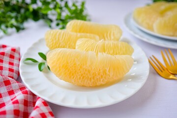 Peeled Pomelo it is a beneficial fruit and high in vitamin c  , in white plateon white table