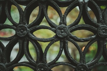 A close-up of a black metal fence with a flower design in Yu Garden, Shanghai, China. The fence is...