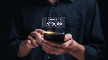 Contact us concept, online customer service. Businessman using smartphone with contact us icon or customer support hotline people connect.