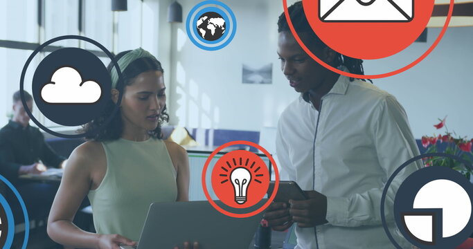 Image of icon in circles over diverse coworkers discussing reports on laptop in office