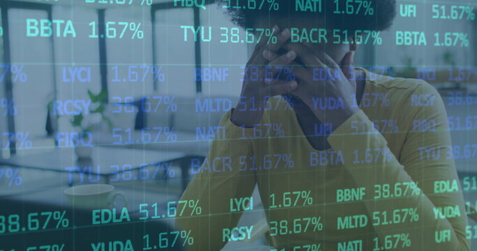 Image of multicolored trading board over tired african american woman working on laptop - Powered by Adobe