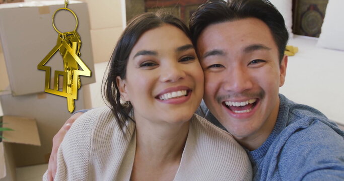 Image of gold house key and key fob over happy diverse couple at new home - Powered by Adobe