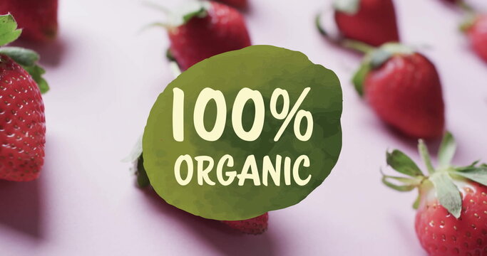 Image of 100 percent organic text over strawberries on pink background