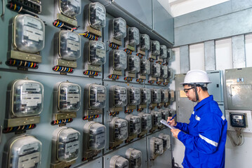 Electrical maintenance engineer checking .Electricity meter and write down value of electricity on...