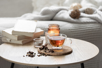 Still life with a cup of tea, books and a candle in a candlestick.