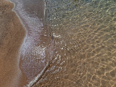 Sea waves on the soft sandy shore of Mediterranean coast.