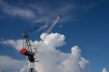 high-rise construction crane on the background of bright blue sky