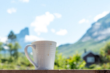 Cup of coffee at the veranda in a mountain hut with a view over Vengedalen valley in Rauma Andalsnes Norway in summer