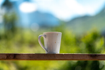 Cup of coffee at the veranda in a mountain hut with a view over Vengedalen valley in Rauma Andalsnes Norway in summer