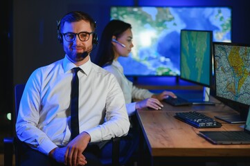 Center of dispatching maintenance. Portrait of cheerful woman and man working via headset...