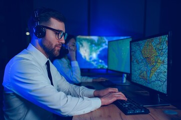Male Data Scientist Works on Personal Computer Control and Monitoring Room. Map Surveillance of...